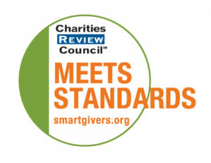Text reads: Charities Review Council Meets Standards, SmartGivers.org. The text is placed on a circular logo with a green outline.